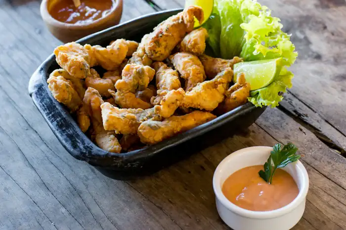 Porção de isca frita com molho e limão