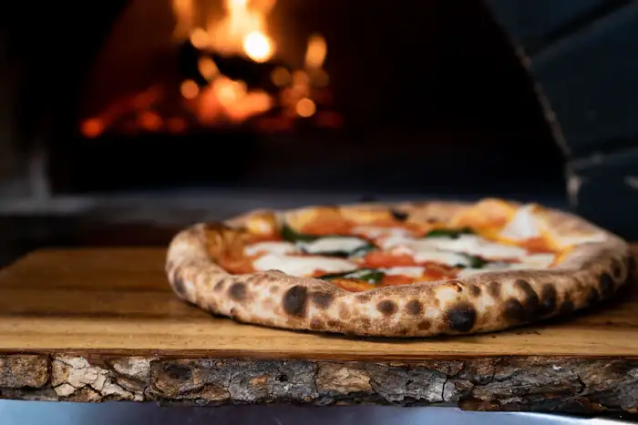 Pizza napolitana em frente ao forno a lenha